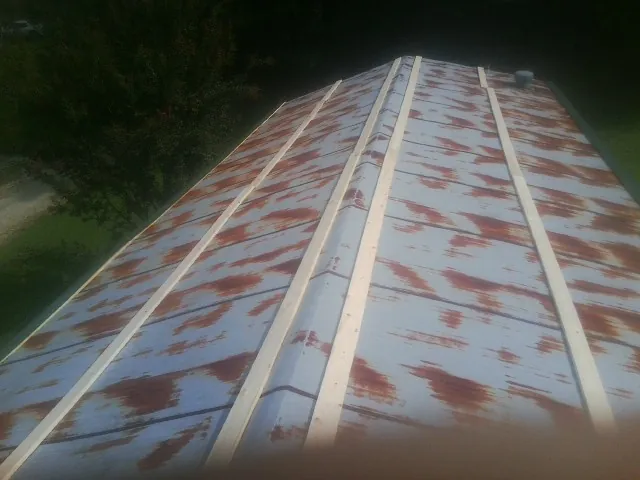 Rusted metal roof panels with new wood purlins before replacement — Storm Damage Roof Repair in Supply by Roofing Brothers