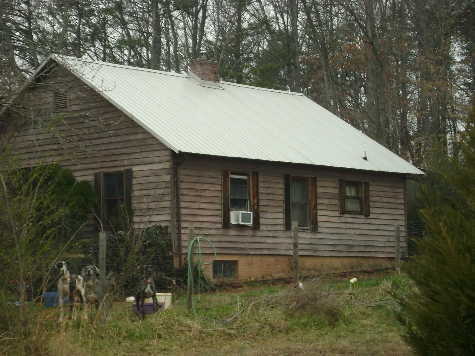 White metal roof on an old wood sided farmhouse, from a Asphalt Shingle Roof Repair job in Supply